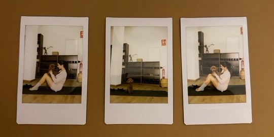 Tres fotos instantáneas colgadas en una pared marrón: en dos, Cristina sentada en una esterilla con Mauro en brazos; en la del medio, Mauro solo en la sala